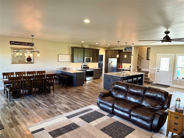 living room with sink, dark hardwood / wood-style flooring, and ceiling fan