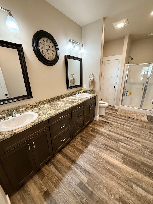 bathroom with vanity, toilet, an enclosed shower, and hardwood / wood-style flooring