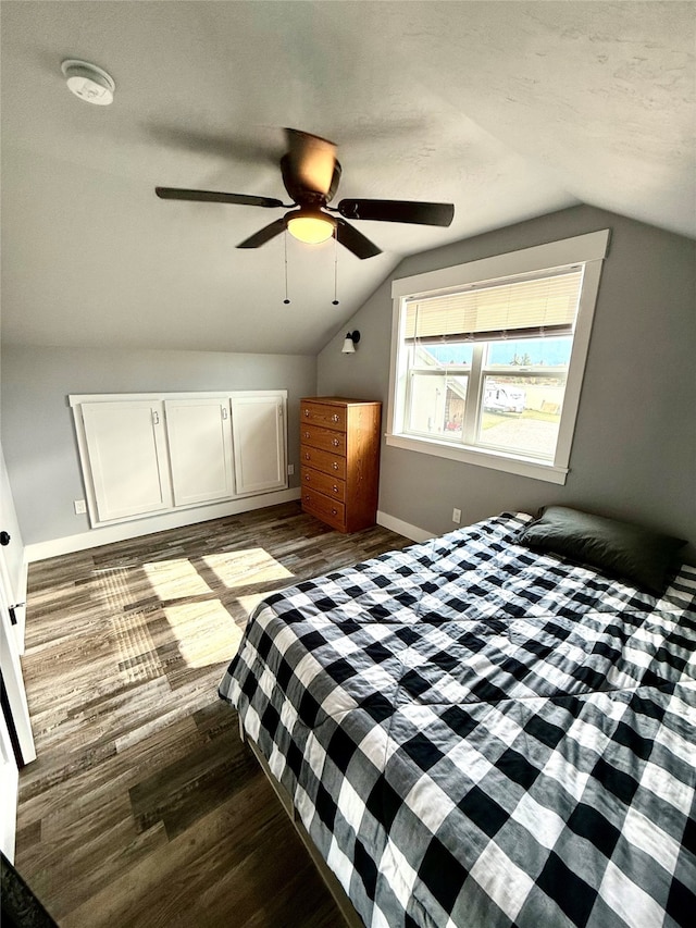 unfurnished bedroom with ceiling fan, hardwood / wood-style flooring, vaulted ceiling, and a textured ceiling