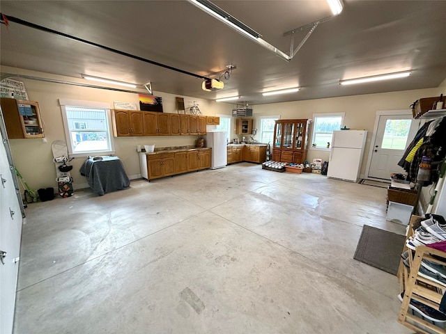 garage featuring a garage door opener and white fridge