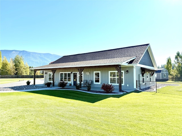 single story home with a front yard, a mountain view, and covered porch