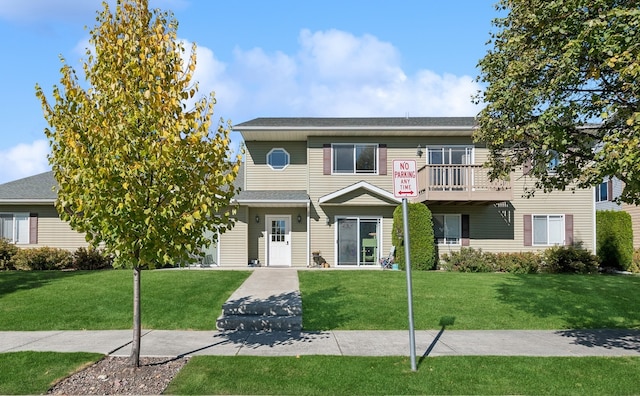 view of front of house featuring a front yard and a balcony