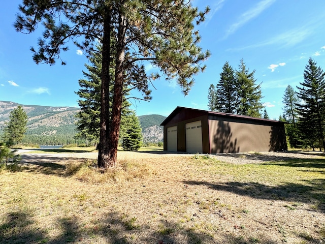 exterior space featuring a mountain view, a garage, and an outbuilding