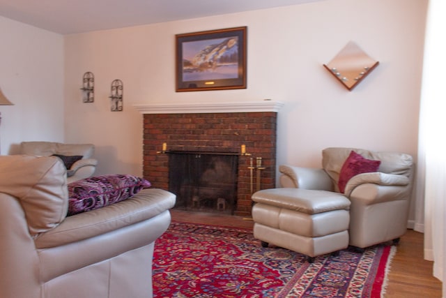 living room with hardwood / wood-style floors and a brick fireplace