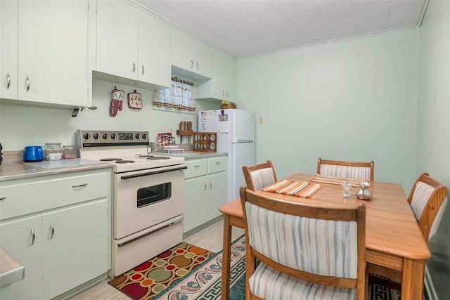 kitchen featuring crown molding, light hardwood / wood-style floors, white cabinets, and white appliances