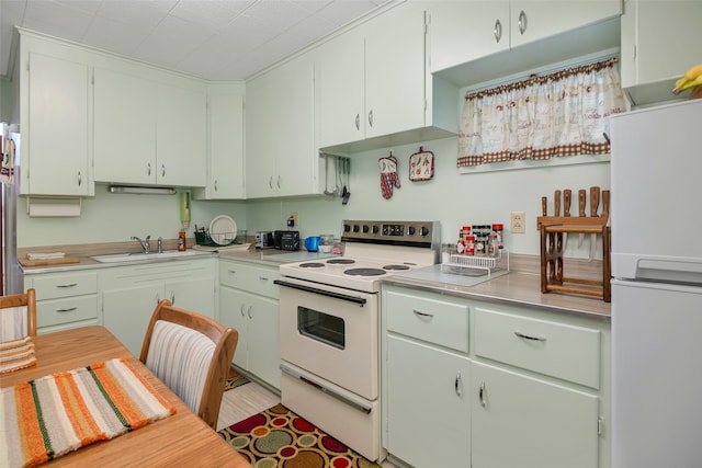 kitchen featuring white cabinetry, sink, and white appliances