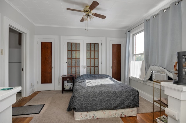 bedroom with ceiling fan, crown molding, light hardwood / wood-style flooring, and french doors