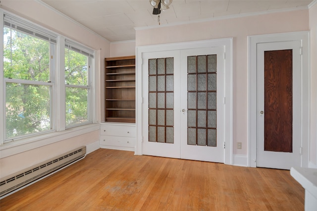 unfurnished sunroom featuring french doors and a baseboard heating unit