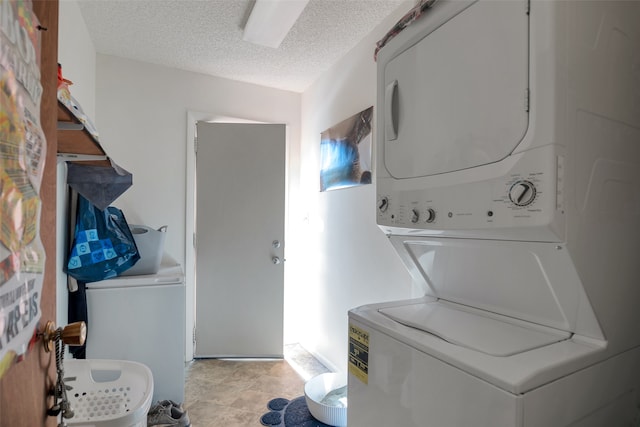 laundry area with stacked washer / dryer and a textured ceiling