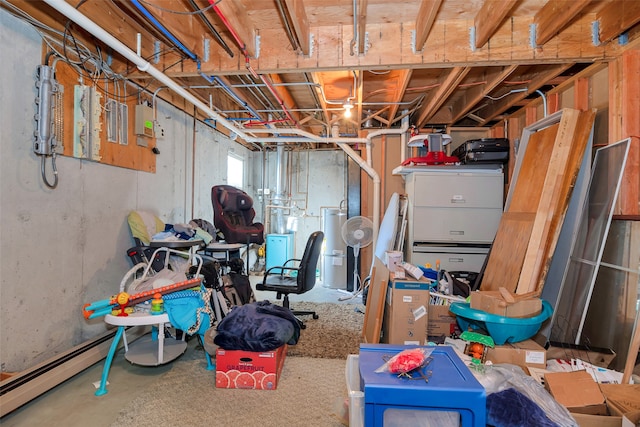 basement featuring baseboard heating and water heater