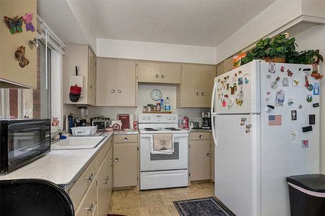 kitchen with cream cabinets, sink, and white appliances