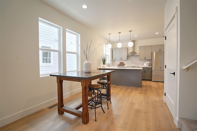 kitchen featuring sink, decorative light fixtures, high quality fridge, gray cabinets, and light hardwood / wood-style floors