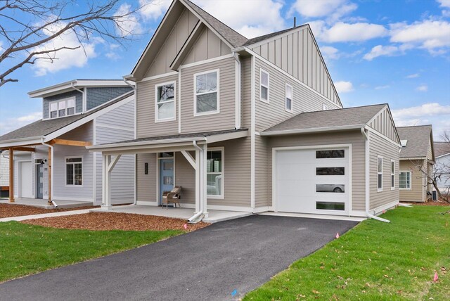 view of front of property with a garage, a front lawn, and a porch