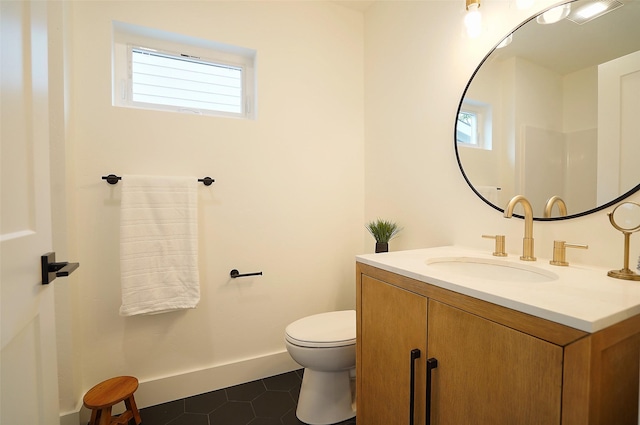 bathroom featuring vanity, a healthy amount of sunlight, tile patterned floors, and toilet