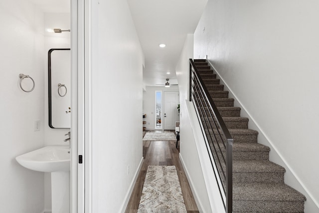 staircase featuring baseboards, recessed lighting, and wood finished floors