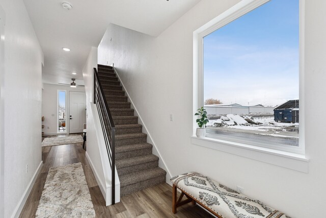 stairs featuring baseboards, wood finished floors, and recessed lighting