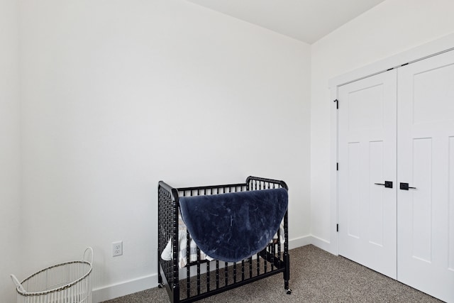 carpeted bedroom featuring baseboards and a closet