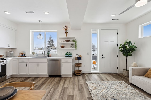 kitchen featuring hanging light fixtures, white cabinetry, a sink, and appliances with stainless steel finishes