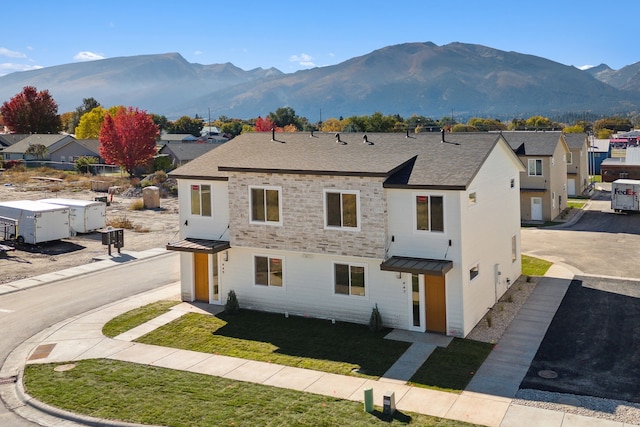 view of front of property featuring metal roof, a standing seam roof, a residential view, and a mountain view