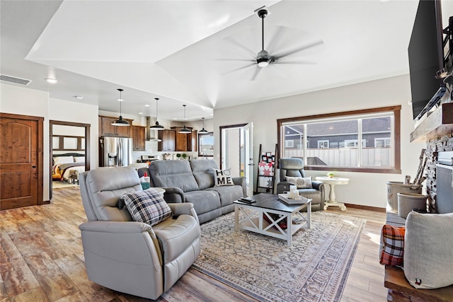 living room with ceiling fan, light hardwood / wood-style floors, and lofted ceiling