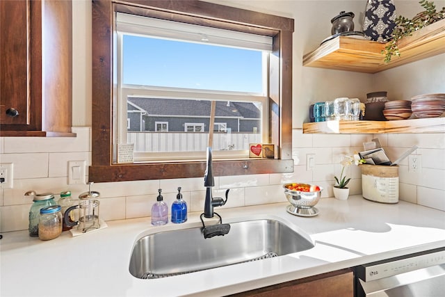 kitchen with tasteful backsplash, dishwasher, and sink