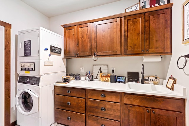 clothes washing area featuring stacked washer and dryer and sink