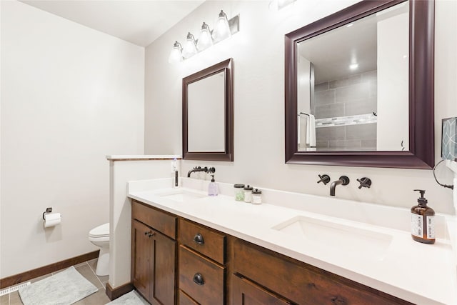 bathroom with tile patterned flooring, vanity, and toilet