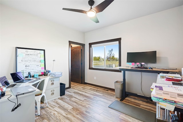 office area with light hardwood / wood-style floors and ceiling fan