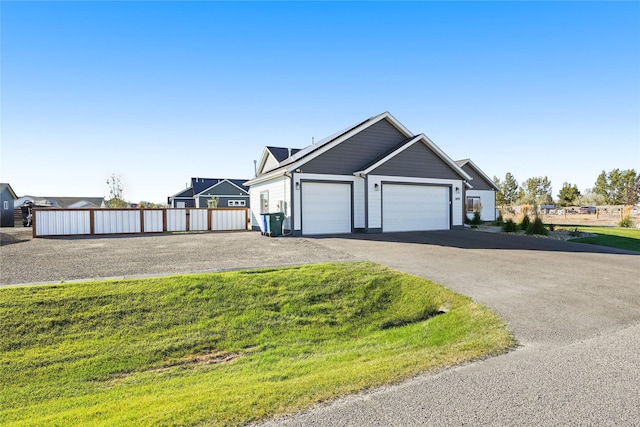 view of front of house with solar panels, a garage, and a front lawn