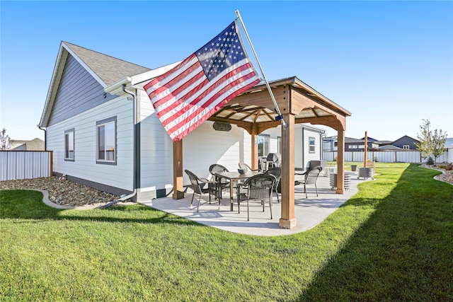 back of property featuring a gazebo, a patio area, and a lawn