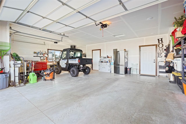 garage with stainless steel fridge and a garage door opener