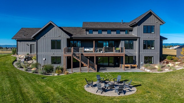 rear view of house featuring a lawn, board and batten siding, a patio area, a fire pit, and stairs