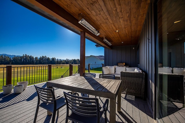 wooden terrace with an outdoor living space