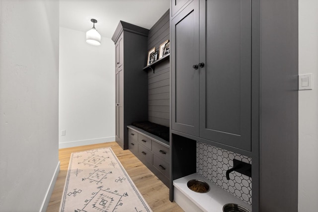 mudroom with light wood finished floors and baseboards