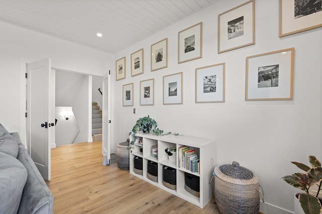 sitting room featuring wooden ceiling, light wood finished floors, and stairs