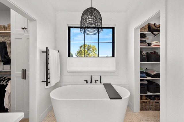 full bath with a soaking tub and a spacious closet