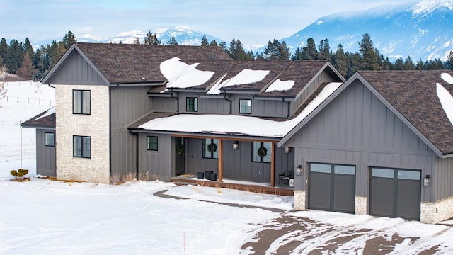 modern inspired farmhouse featuring a garage, stone siding, board and batten siding, and a mountain view