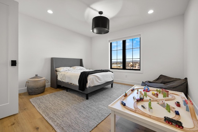 bedroom with baseboards, recessed lighting, and light wood-style floors