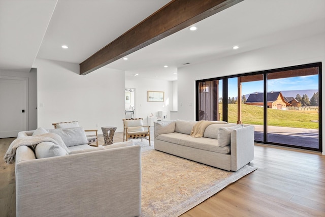 living area with light wood-style floors, recessed lighting, and beamed ceiling