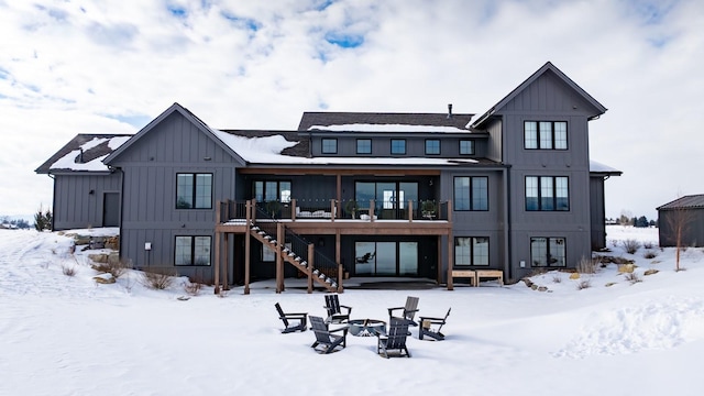 snow covered property featuring stairway, board and batten siding, and a wooden deck