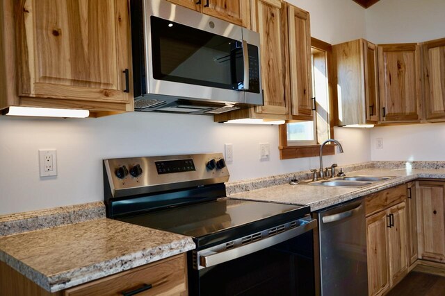 72 River Ct N, Eureka, MT 59917 - kitchen with stainless steel appliances, light stone countertops, brown cabinets, and a sink