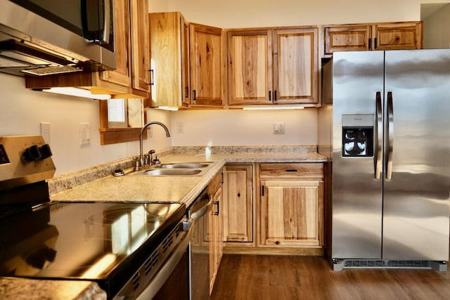 72 River Ct N, Eureka, MT 59917 - kitchen with light stone countertops, dark wood-type flooring, brown cabinetry, appliances with stainless steel finishes, and a sink