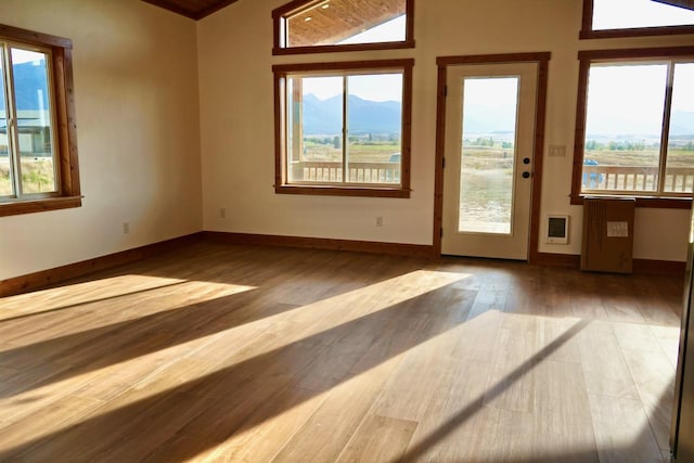 72 River Ct N, Eureka, MT 59917 - interior space with wood finished floors, a mountain view, baseboards, and lofted ceiling