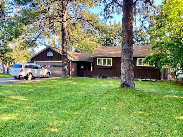 single story home featuring a garage and a front lawn