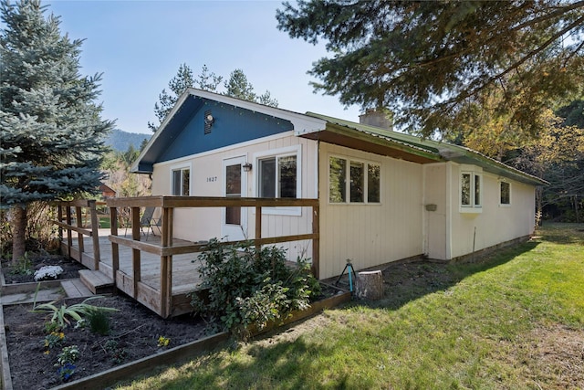 1627 Foothill Rd, Kalispell, MT 59901 - view of home's exterior with a deck, a chimney, and a lawn