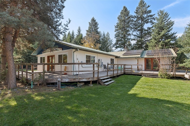 1627 Foothill Rd, Kalispell, MT 59901 - rear view of house featuring roof mounted solar panels, a lawn, metal roof, a deck, and a chimney