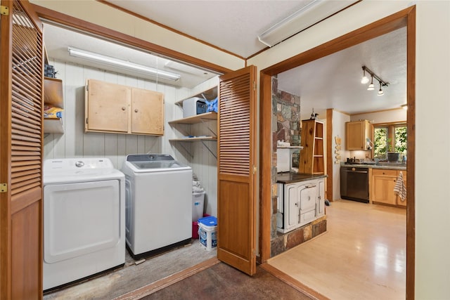 1627 Foothill Rd, Kalispell, MT 59901 - washroom with cabinet space, separate washer and dryer, wooden walls, and light wood-style flooring
