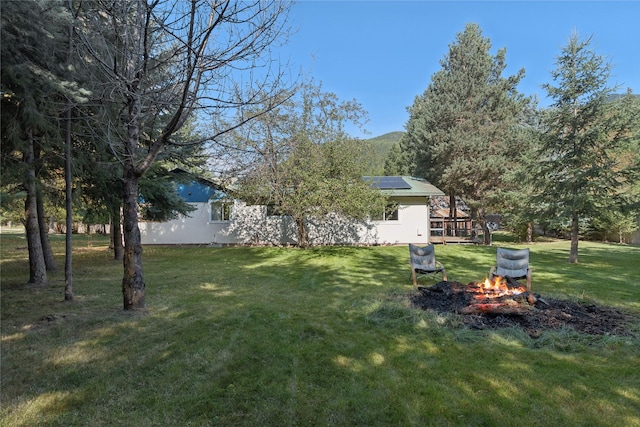 1627 Foothill Rd, Kalispell, MT 59901 - view of green lawn featuring a fire pit and a deck