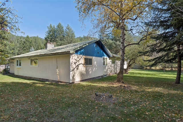 1627 Foothill Rd, Kalispell, MT 59901 - view of home's exterior featuring a yard and a chimney