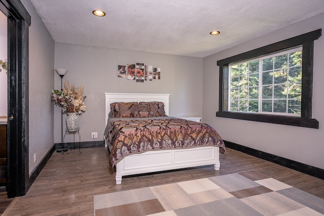 bedroom featuring wood-type flooring and a textured ceiling